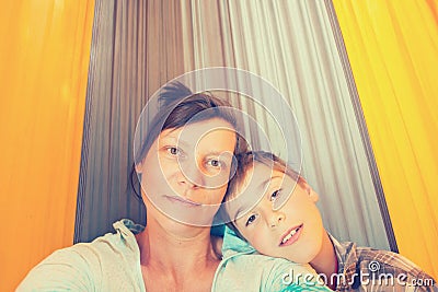 Happy mother and son is resting in a hammock and taking selfie Stock Photo