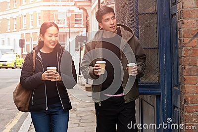 Happy mother with son walking on the street with takeaway coffee in there hands. Stock Photo