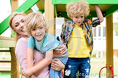 happy mother with two adorable playful little boys at playground Stock Photo