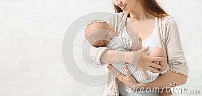 Young woman singing lullaby to her newborn baby and smiling Stock Photo