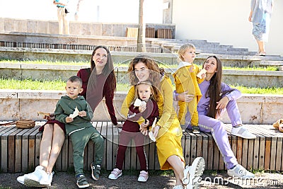 Happy mothers with children in fashionable sportswear in family style Stock Photo