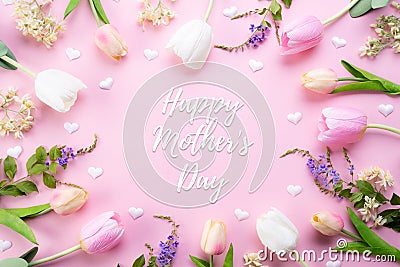 Happy mothers day concept. Top view of pink tulip flowers in frame with happy mother`s day text on pink pastel background. Flat Stock Photo