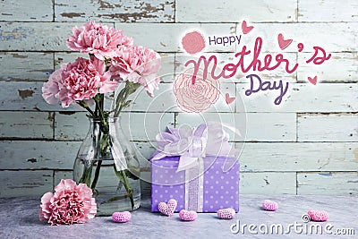 Happy mothers day message on wood background and pink carnation Stock Photo