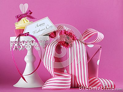 Happy Mothers Day pink heart cupcake on white cupcake stand with gift Stock Photo