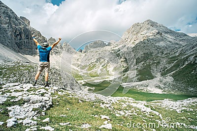 Happy mountaineer raising his arms in front of the panorama Stock Photo