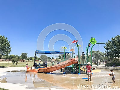 Happy multicultural kids and parent playing at splash park in Texas in post COVID-19 pandemic Editorial Stock Photo