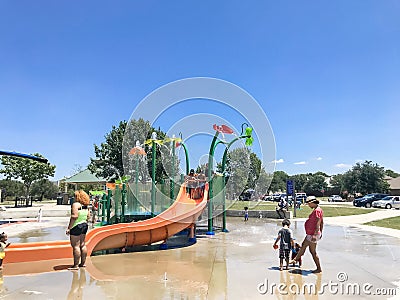 Happy multicultural kids and parent playing at splash park in Texas in post COVID-19 pandemic Editorial Stock Photo