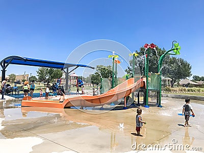 Happy multicultural kids and parent playing at splash park in Texas in post COVID-19 pandemic Editorial Stock Photo