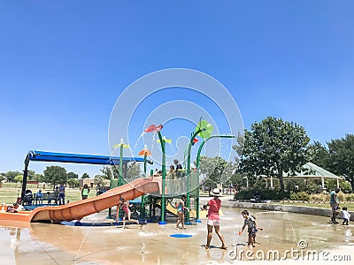 Happy multicultural kids and parent playing at splash park in Texas in post COVID-19 pandemic Editorial Stock Photo