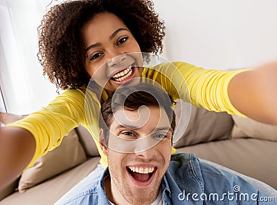 Happy multiethnic couple taking selfie at home Stock Photo