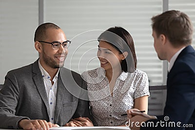 Happy multiethnic couple visiting banker or broker in office Stock Photo