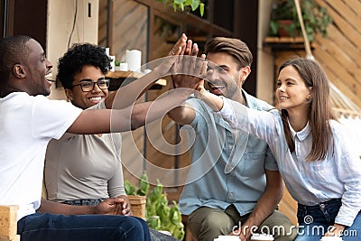 Happy multiethnic friends giving high five, celebrate success Stock Photo