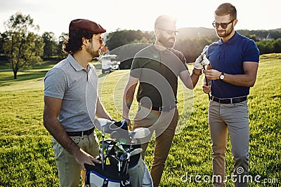 Happy multiethnic golfers spending time together in golf course Stock Photo