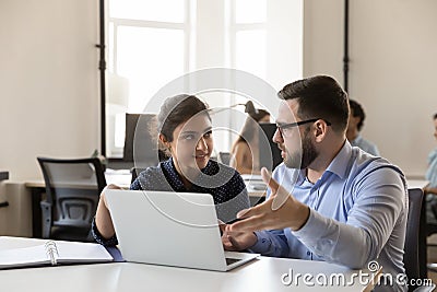 Happy multiethnic office colleagues employees talking at shared laptop Stock Photo
