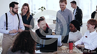 Happy multiethnic smiling group working together at loft office, brainstorming with middle aged boss at conference. Stock Photo