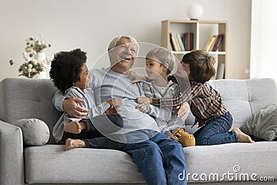 Happy multigenerational family enjoy playtime seated on sofa at home Stock Photo