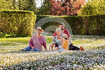 Happy multigenerational family in straw hats having fun during picnic Stock Photo