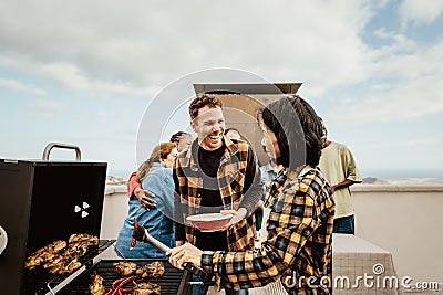 Happy multigenerational people having fun doing barbecue grill at house rooftop Stock Photo