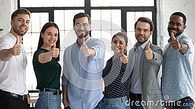 Happy multiracial businesspeople show thumbs up recommending service Stock Photo