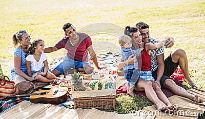 Happy multiracial families taking selfie at pic nic garden party - Multicultural joy and love concept with mixed race people Stock Photo