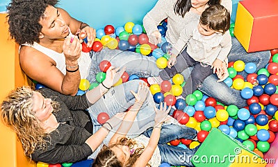 Happy multiracial mom and dad playing with daughter at gameroom Stock Photo