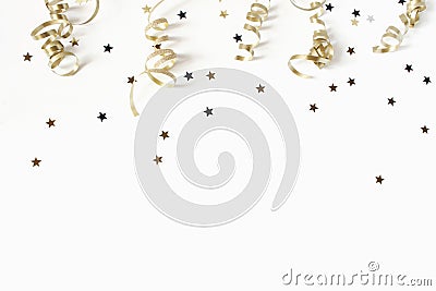 Happy New Year or birthday festive composition. Golden confetti and glittering stars on white table background Stock Photo