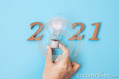 2021 Happy New year with Businessman holding lightbulb with and wooden number. New Start, Idea, Creative, Innovation, Resolution, Stock Photo