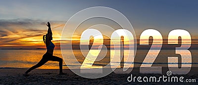 Happy new year card 2023. Silhouette lifestyle woman yoga practicing yoga standing as part of Number 2023 near the beach at sunset Stock Photo