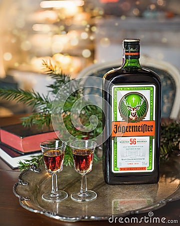 Happy new year or christmas background with Jagermeister alcohol drink, elixir. Bottle of Jagermeister with glasses on a vintage t Editorial Stock Photo