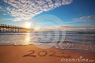 Happy New Year 2023 concept, lettering on the beach. Written text on the sea beach at sunrise Stock Photo