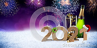 Happy new year eve 2021 number colorful fireworks with santa hat four leaf clover champagne bottle glass on snow front of red Stock Photo