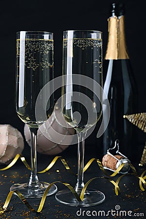 Happy New Year! Glasses of sparkling wine and festive decor on black background Stock Photo