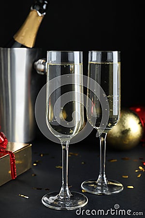 Happy New Year! Glasses with sparkling wine on table against black background Stock Photo