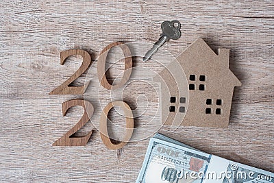 2020 Happy New Year with house model and money on wooden background. Banking, real estate, investment, financial, savings and New Stock Photo
