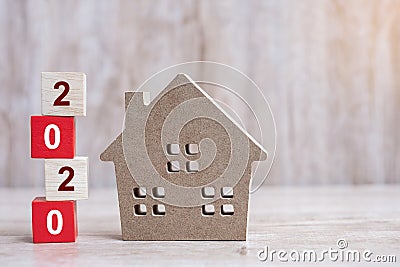 2020 Happy New Year with house model on wooden background. Banking, real estate, investment, financial, savings and New Year Stock Photo