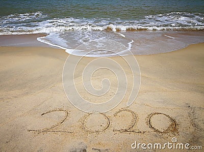 Happy new year 2020,lettering on the beach with wave and clear blue sea. Numbers 2020 year on the sea shore. Beautiful beach. Stock Photo