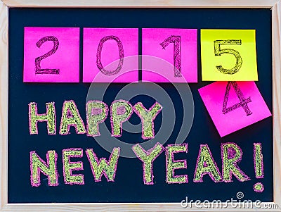 Happy New Year 2015 message hand written on blackboard, numbers stated on post-it notes, 2015 replacing 2014 Stock Photo