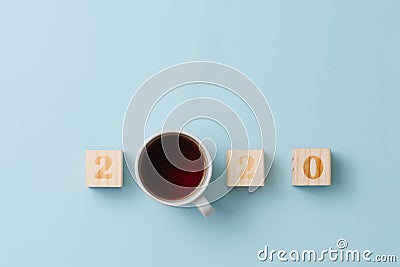 Happy new year composition. 2020 number and tea in a cup over blue background. Stock Photo