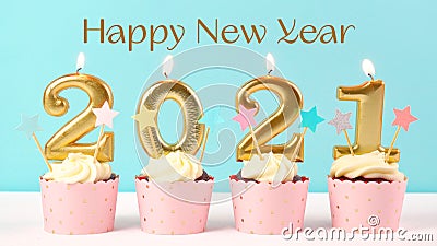 2021 Happy New Year`s Eve cupcakes with gold candles. Stock Photo
