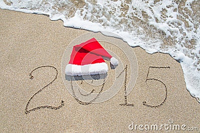 Happy new year 2015 with smiley face in santa hat on sandy beach Stock Photo