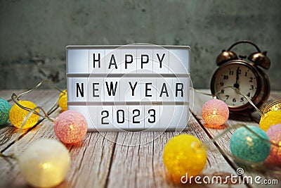 Happy New Year 2023 text on lightbox on wooden background Stock Photo