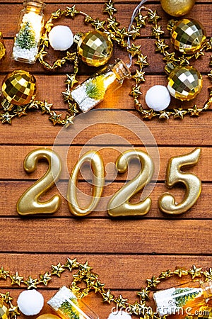 Happy New Year wooden numbers 2025 on cozy festive brown wooden background with sequins, snow, lights of garlands. Greetings, Stock Photo