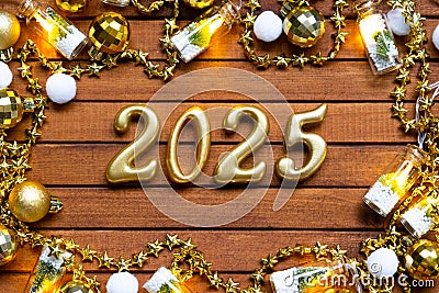 Happy New Year wooden numbers 2025 on cozy festive brown wooden background with sequins, snow, lights of garlands. Greetings, Stock Photo