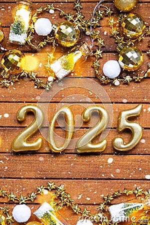 Happy New Year wooden numbers 2025 on cozy festive brown wooden background with sequins, snow, lights of garlands. Greetings, Stock Photo
