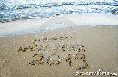 Happy new year written on the sand. Stock Photo