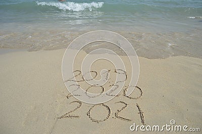 2019, 2020, 2021 handwritten on sandy beach shore Stock Photo
