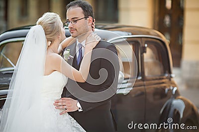 Happy newlywed couple, man and wife hugging near stylish retro c Stock Photo