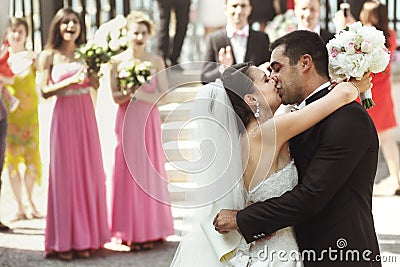 Happy newlywed married couple husband and bride kissing near arbor Stock Photo