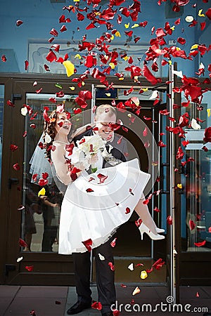 Happy newlyweds bride and groom with petals Stock Photo