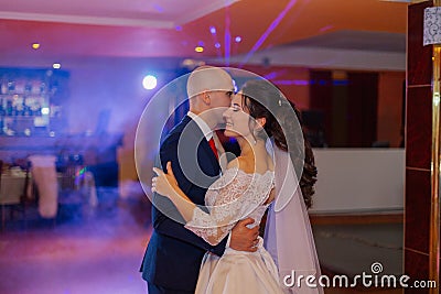 Happy newlyweds dance on the dance floor the first dance. Stock Photo